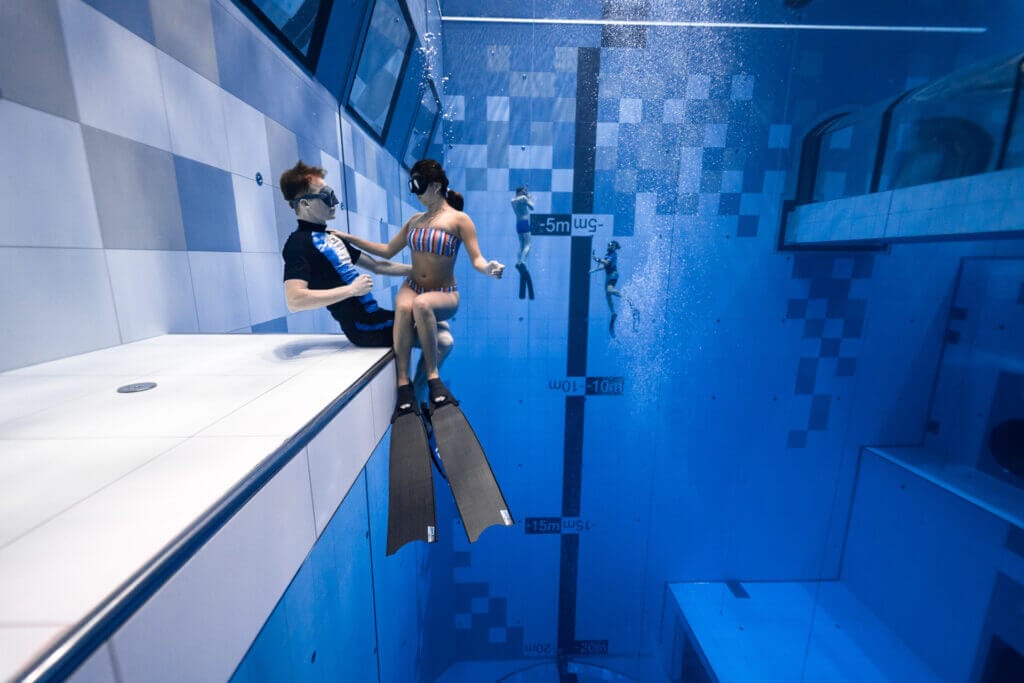Couple plongeant dans la piscine Deepspot